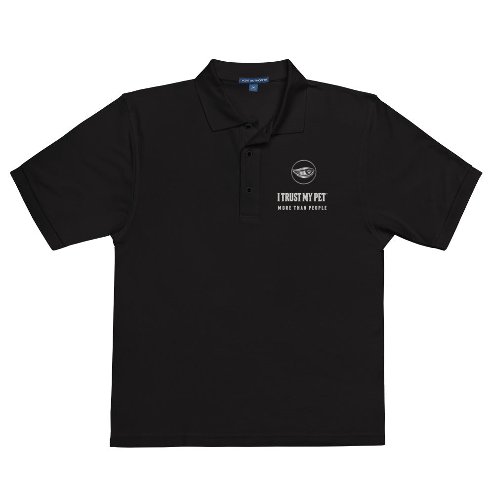 Black Quiet Authority men’s polo laid flat, with the I Trust My Pet™ eye-and-paw, name and More than people embroidered chest badge.