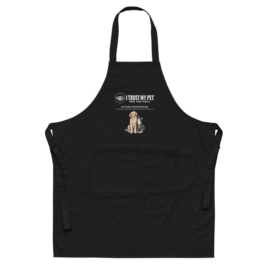 Black Kitchen Supervision organic cotton apron with complete I Trust My Pet™ logo and squinty side-eye dog-and-cat illustration, full front flat-lay view.