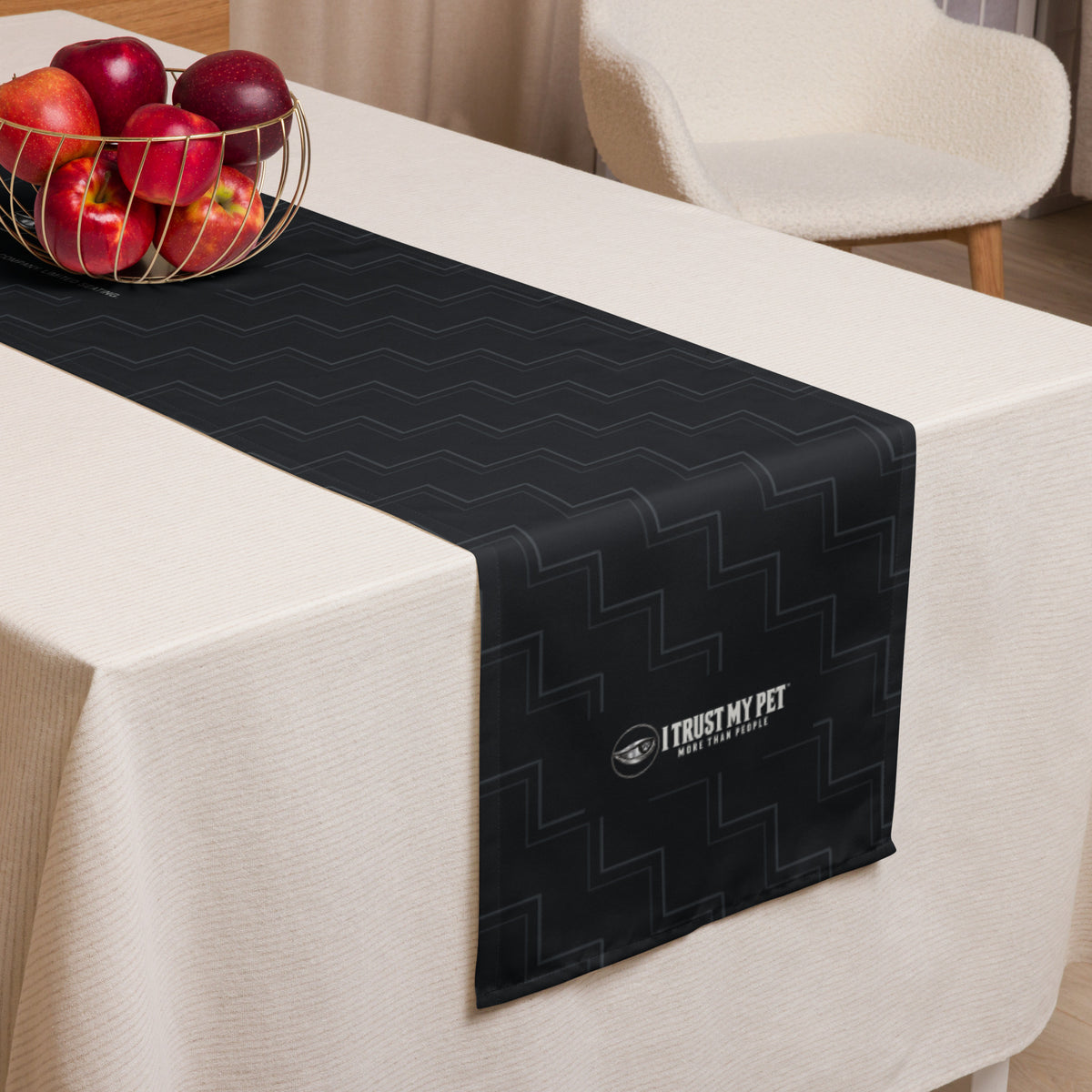 I Trust My Pet™ Quiet Company black table runner styled on a table, showing charcoal linework and the signature logo at the hanging end.